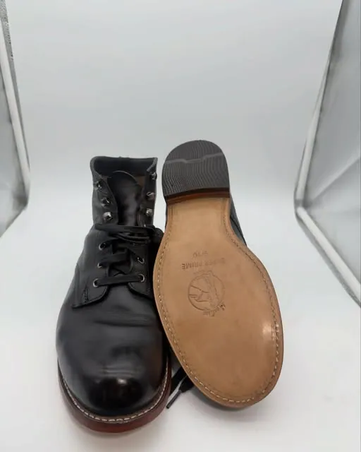 A black lace-up boot with a new stitched tan leather sole