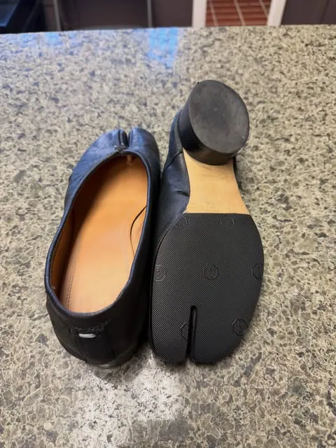 A black leather Tabi flat and its freshly fitted split-toe sole