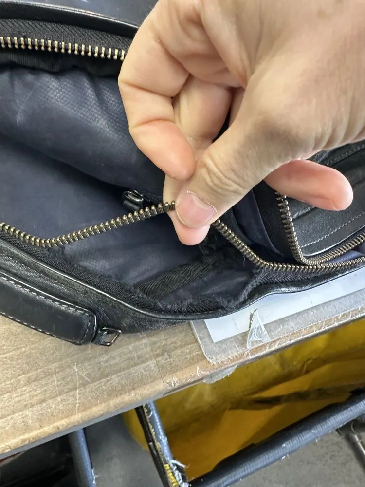 A Tumi leather bag in for a zipper and a top handle