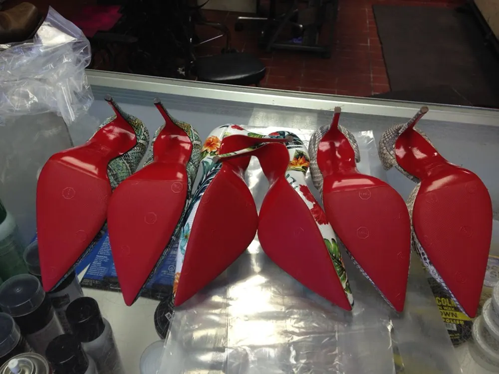 A row of red-soled heels hanging up after repair