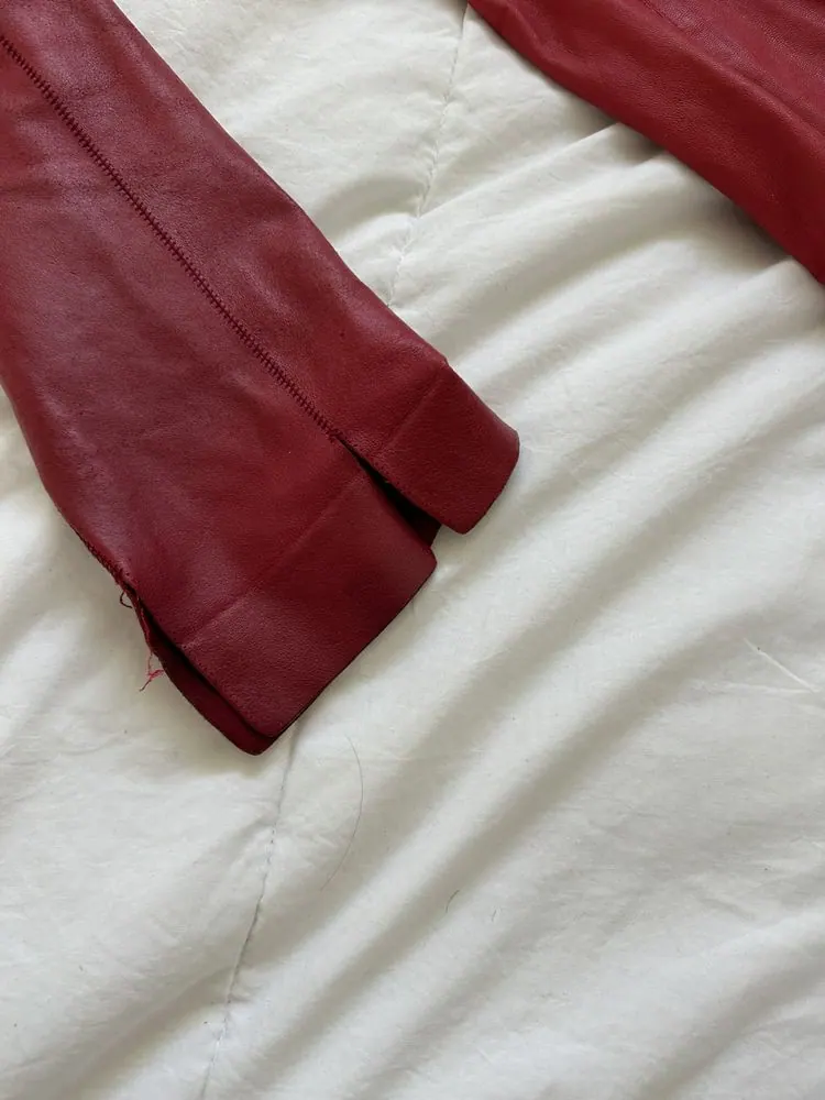 A red leather coat laid out for repair