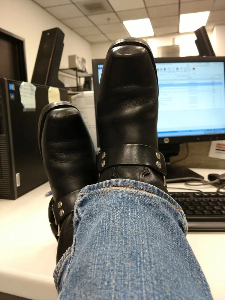 A pair of black harness boots finished with a deep shine